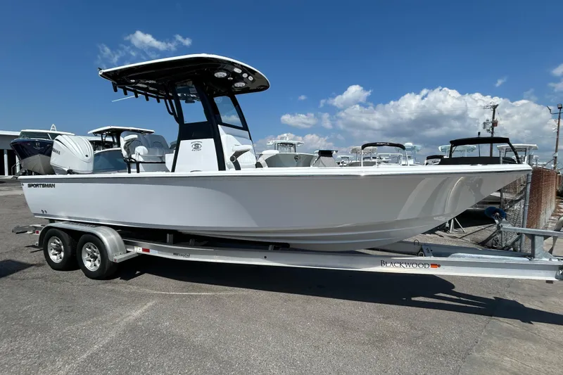 Slide: The Image of 2026 Sportsman Masters 247OE Bay Boat on trailer under clear blue sky. - 2