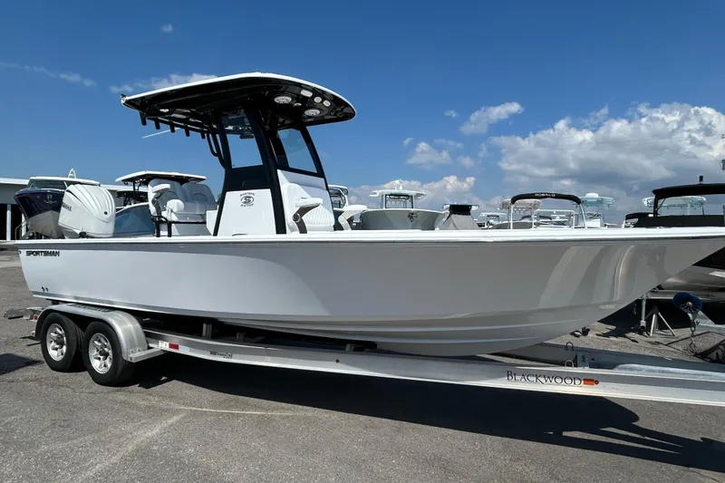 Slide: The Image of 2026 Sportsman Masters 247OE Bay Boat on trailer under clear blue sky. - 3