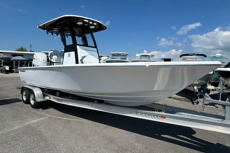Slide: The Image of 2026 Sportsman Masters 247OE Bay Boat on trailer under clear blue sky. - 4