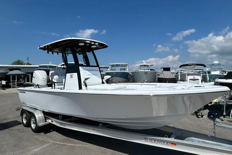 Slide: The Image of 2026 Sportsman Masters 247OE Bay Boat on trailer under clear blue sky. - 6