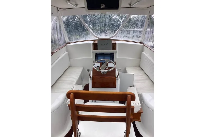 Slide: The Image of Interior of 2006 Calyber 29 Express boat with wooden helm and seating. - 11