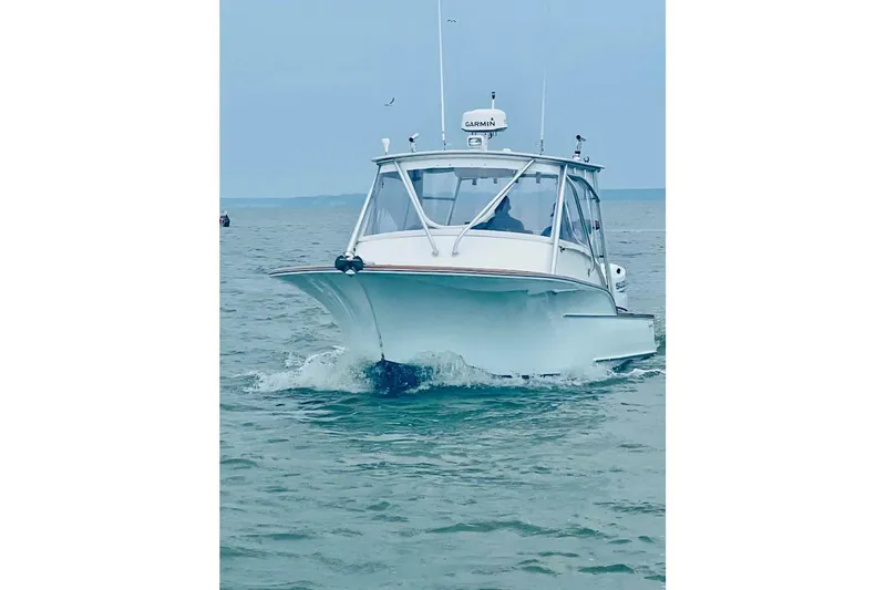 Slide: The Image of 2006 Calyber 29 Express boat on trailer, parked outdoors under cloudy sky. - 3