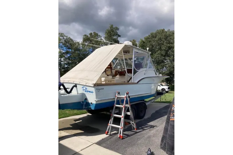 Slide: The Image of 2006 Calyber 29 Express boat cruising on a calm river with trees in the background. - 4
