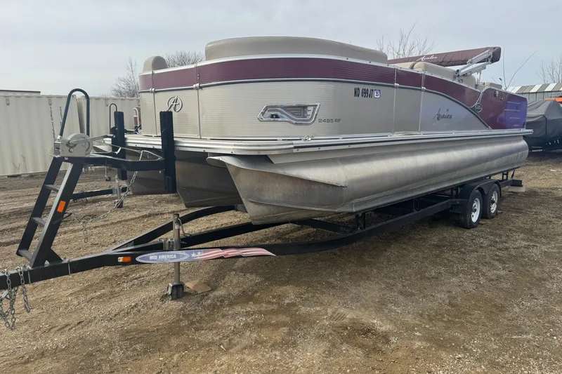 The Image of 2014 Avalon Windjammer Fish 24' pontoon boat on trailer, parked outdoors. - 1