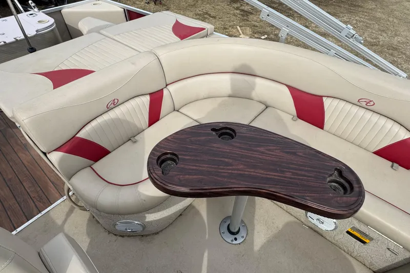 Slide: The Image of 2014 Avalon Windjammer Fish 24' boat interior with beige and red seating, wooden table. - 10