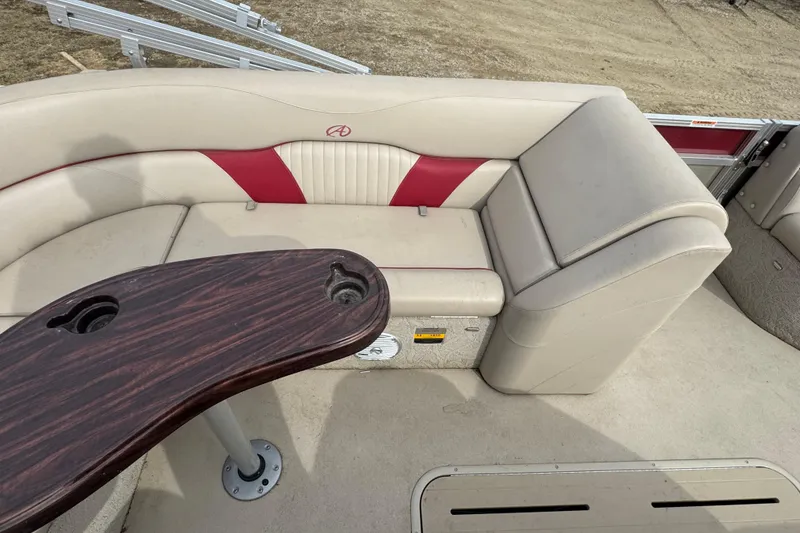 Slide: The Image of 2014 Avalon Windjammer Fish 24' boat interior with beige and red seating, wooden table. - 11