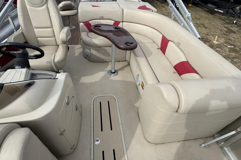 Slide: The Image of 2014 Avalon Windjammer Fish 24' boat interior with beige and red seating, steering console, and table. - 7