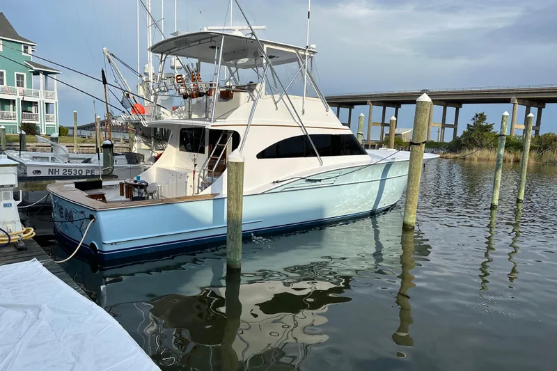 Slide: The Image of 2004 Hudson Custom Carolina boat docked near a bridge, reflecting on calm water. - 47