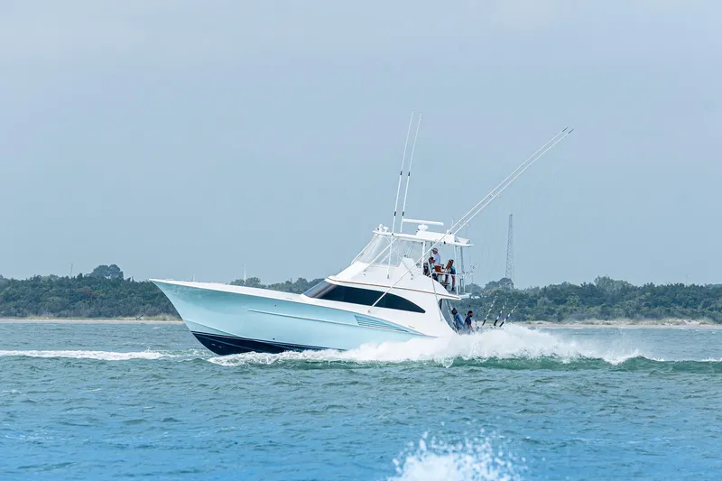 Slide: The Image of 2004 Hudson Custom Carolina yacht cruising on open water near a forested shoreline. - 51
