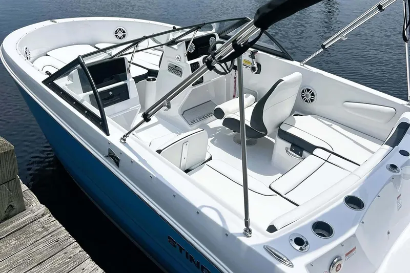 Slide: The Image of Manufacturer Provided Image: 2026 Stingray 172 DC boat with sleek white interior and blue exterior, docked by water. - 12