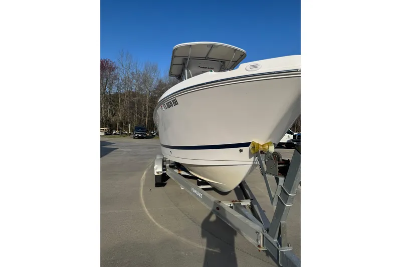 The Image of 2007 PROLINE 23 Sport boat on trailer, parked outdoors under clear blue sky. - 0