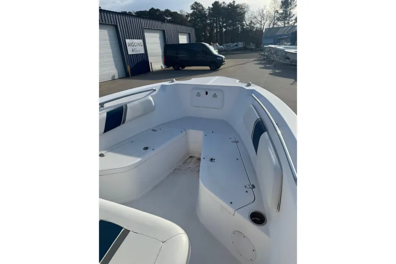 Slide: The Image of 2007 PROLINE 23 Sport boat interior with seating and storage, parked near a rigging facility. - 7