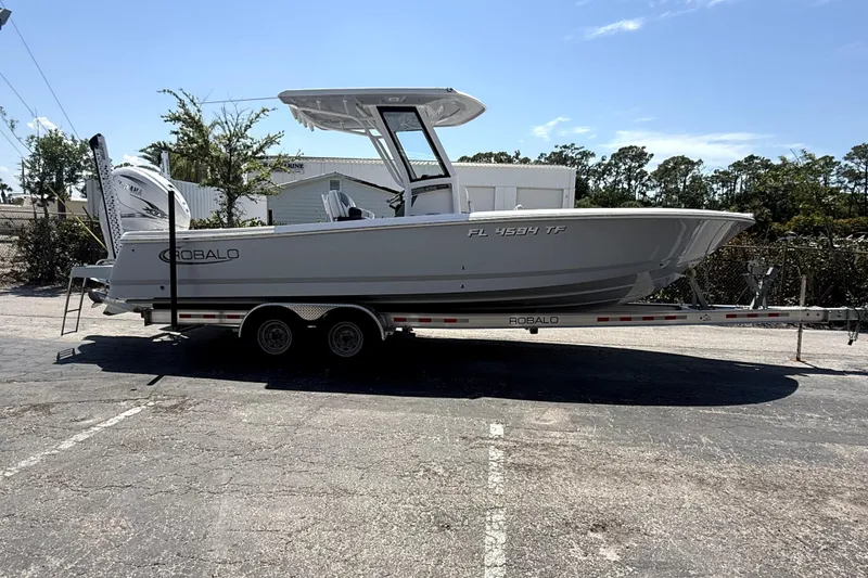 The Image of 2022 Robalo 266 Cayman boat on trailer in parking lot, side view. - 0