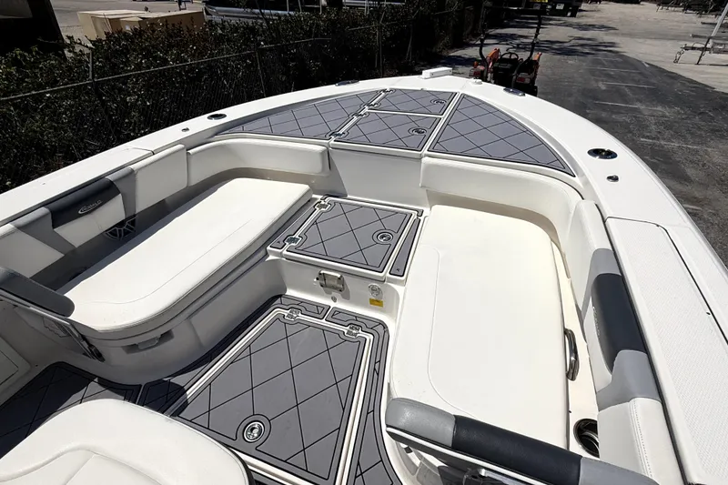 Slide: The Image of 2022 Robalo 266 Cayman boat interior with cushioned seating and storage compartments. - 12