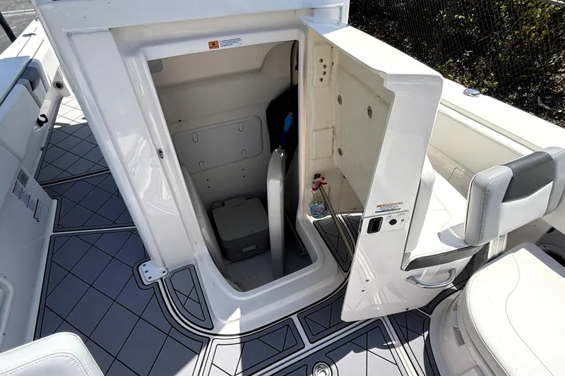 Slide: The Image of 2022 Robalo 266 Cayman boat interior with open storage compartment and seating. - 13