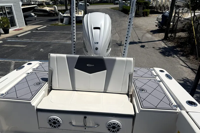 Slide: The Image of 2022 Robalo 266 Cayman boat interior with seating and motor, parked in a marina. - 5