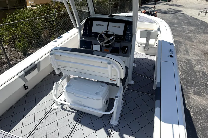 Slide: The Image of 2022 Robalo 266 Cayman boat interior with helm, seating, and Simrad electronics. - 8