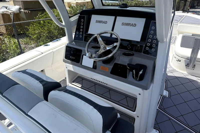 Slide: The Image of 2022 Robalo 266 Cayman boat cockpit with dual Simrad displays and steering wheel. - 9