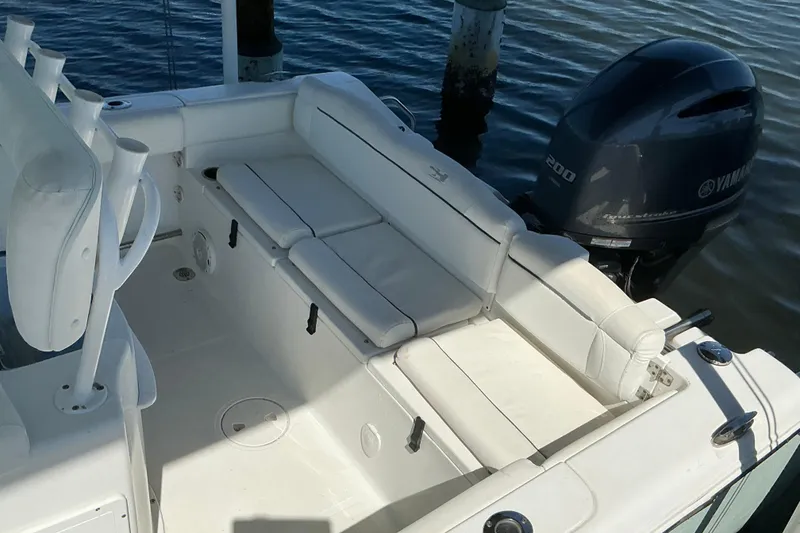Slide: The Image of 2016 Sea Hunt Ultra 225 boat interior with Yamaha 200 engine, white seating, and rod holders. - 11