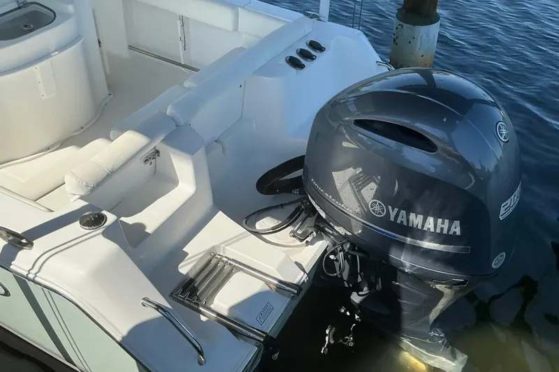 Slide: The Image of 2016 Sea Hunt Ultra 225 boat with Yamaha outboard motor, docked on calm water. - 12