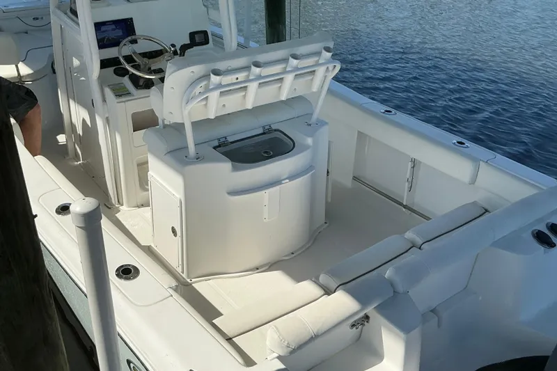Slide: The Image of 2016 Sea Hunt Ultra 225 boat interior with seating and steering console on water. - 13