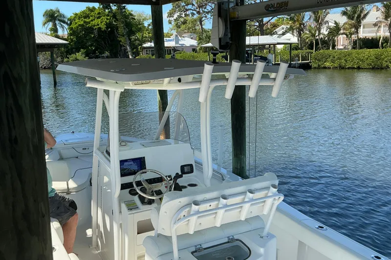Slide: The Image of 2016 Sea Hunt Ultra 225 boat docked on a serene waterfront. - 14