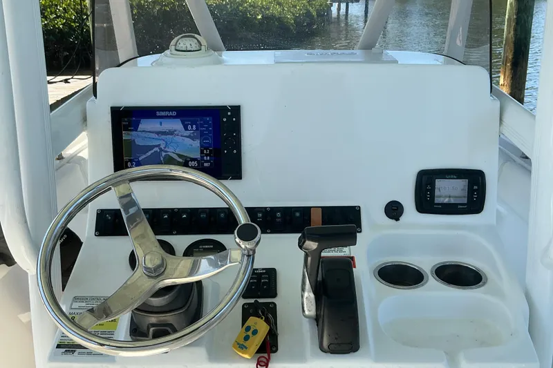 Slide: The Image of 2016 Sea Hunt Ultra 225 boat dashboard with steering wheel and navigation system. - 16
