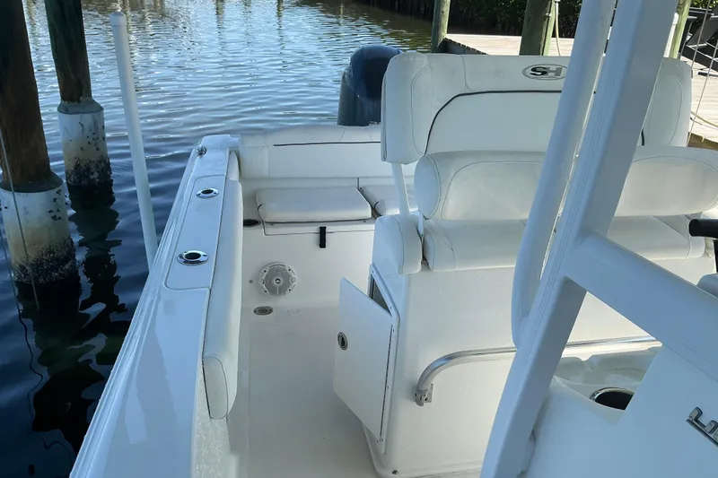 Slide: The Image of 2016 Sea Hunt Ultra 225 boat interior with white seating and fishing rod holders. - 25