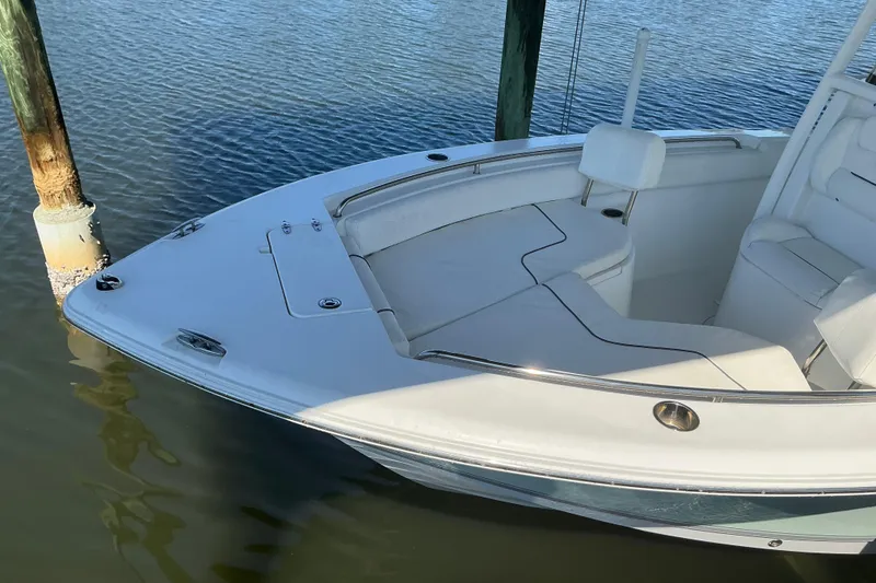 Slide: The Image of 2016 Sea Hunt Ultra 225 boat docked on calm water, showcasing sleek design and seating area. - 3