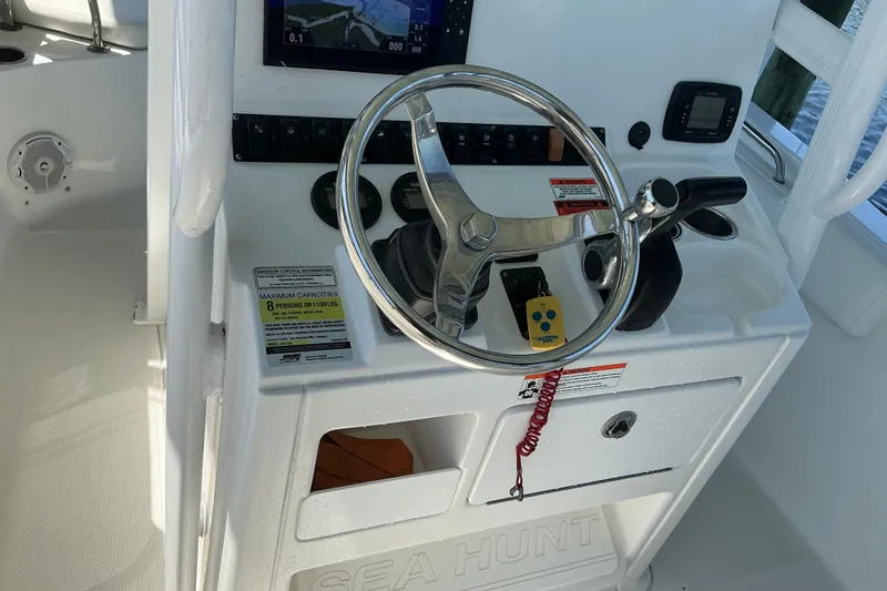 Slide: The Image of 2016 Sea Hunt Ultra 225 boat console with steering wheel and controls. - 31