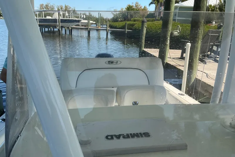 Slide: The Image of 2016 Sea Hunt Ultra 225 boat docked by a serene waterfront. - 32