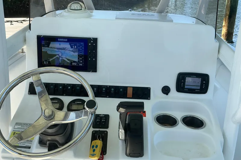 Slide: The Image of 2016 Sea Hunt Ultra 225 boat dashboard with steering wheel and navigation instruments. - 34