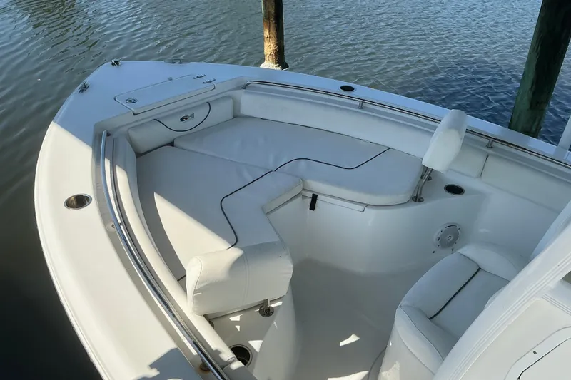 Slide: The Image of 2016 Sea Hunt Ultra 225 boat interior with white seating and water view. - 7