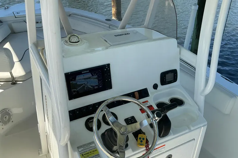 Slide: The Image of 2016 Sea Hunt Ultra 225 boat console with steering wheel and navigation equipment. - 8