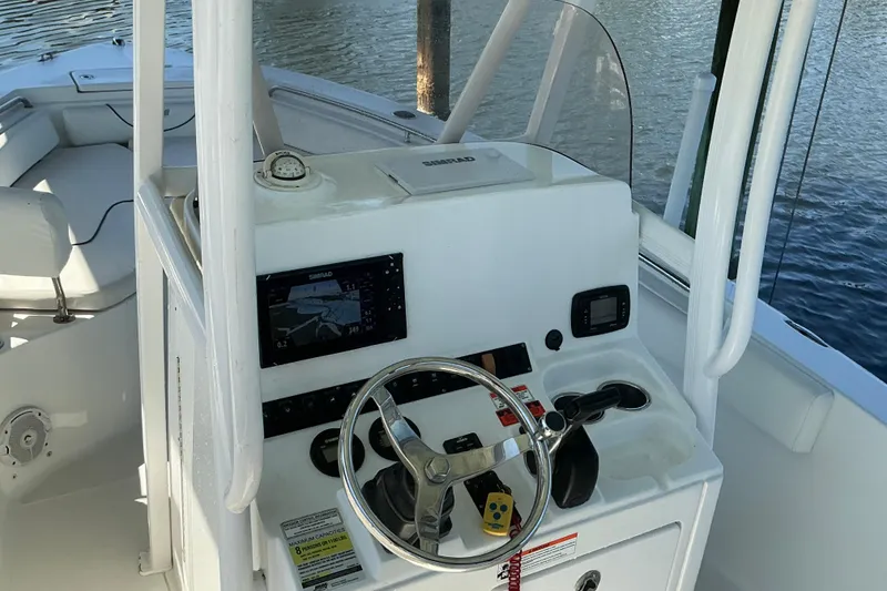 Slide: The Image of 2016 Sea Hunt Ultra 225 boat dashboard with steering wheel and navigation equipment. - 9