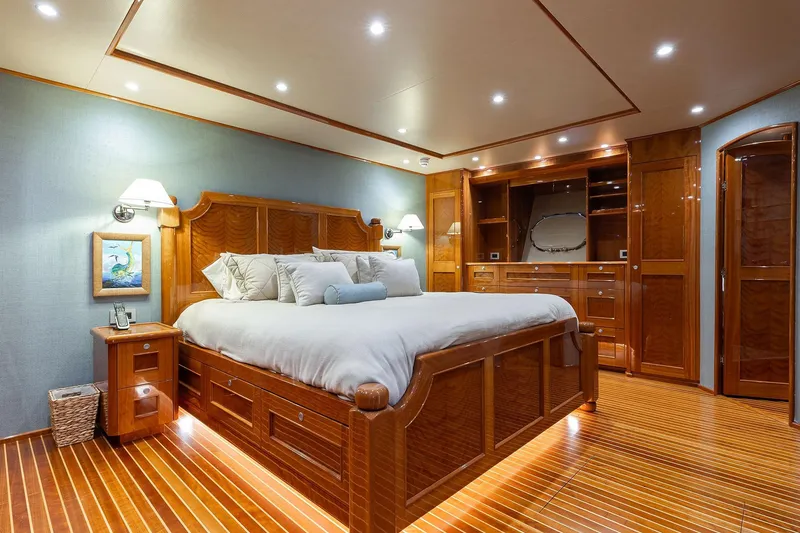 Slide: The Image of Luxurious bedroom interior on 2016 Viking 82 Sky Bridge yacht, featuring elegant wood finishes. - 19