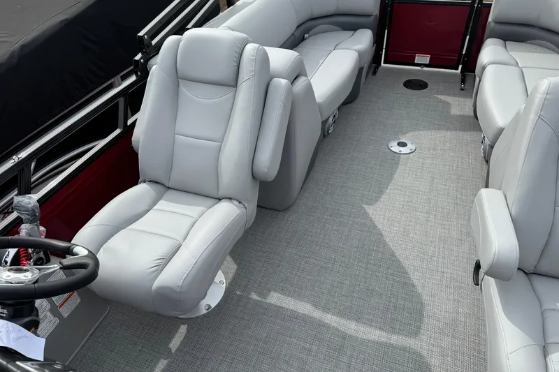 Slide: The Image of 2025 Regency 230 DL3 boat interior with plush gray seating and modern steering wheel. - 9