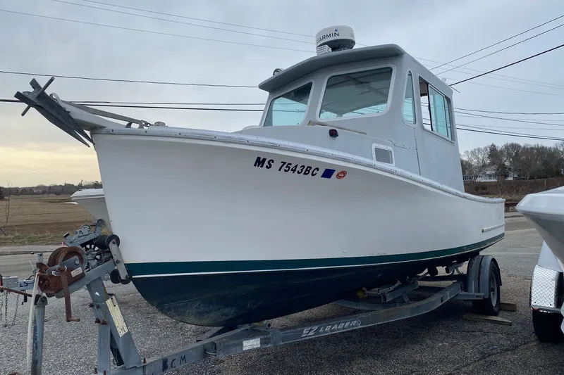 The Image of 1985 SISU Lobster Boat 22' on trailer, white hull, parked outdoors. - 0