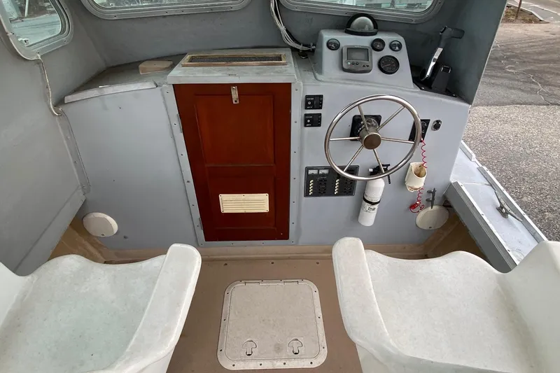 Slide: The Image of 1985 SISU Lobster Boat cockpit with steering wheel, control panel, and seating. - 11
