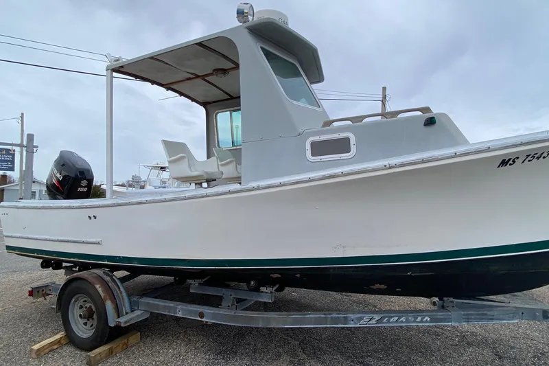 Slide: The Image of 1985 SISU Lobster Boat 22' on trailer, featuring outboard motor and cabin. - 2