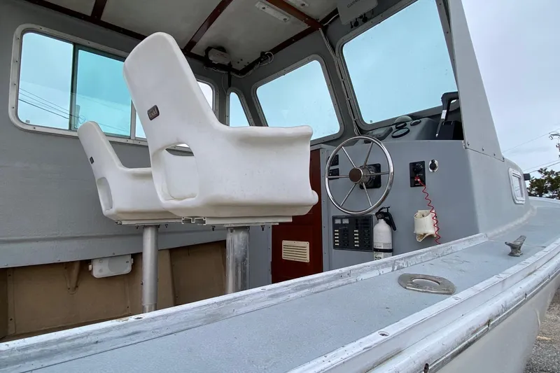 Slide: The Image of 1985 SISU Lobster Boat interior with steering wheel, white seats, and control panel. - 3