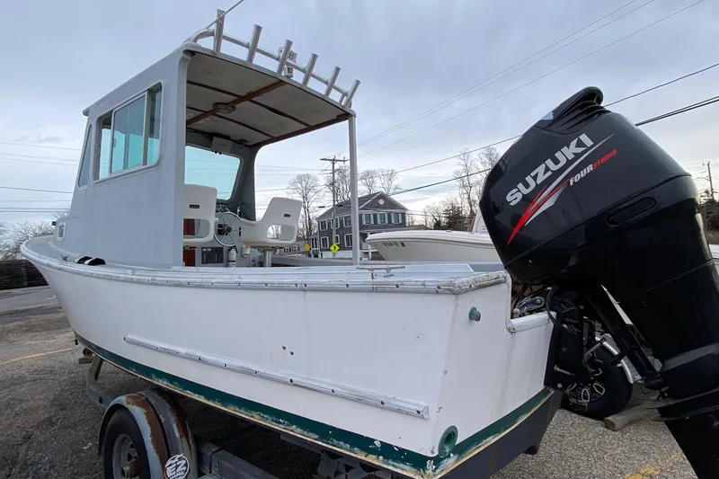 Slide: The Image of 1985 SISU Lobster Boat 22' with Suzuki outboard motor, parked on a trailer. - 5