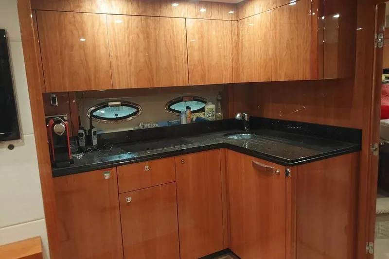 Slide: The Image of Luxurious 2012 Sunseeker Portofino 48 yacht kitchen with sleek wood cabinetry and modern appliances. - 10