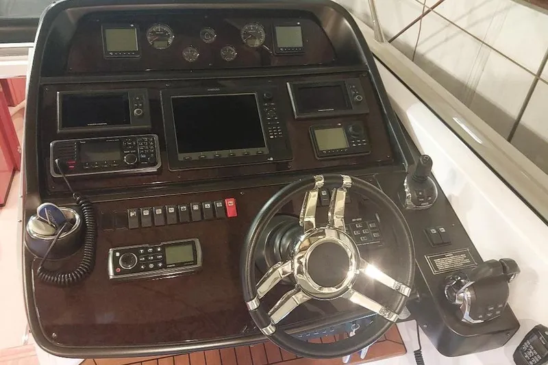 Slide: The Image of Control panel of a 2012 Sunseeker Portofino 48 yacht with steering wheel and navigation instruments. - 3