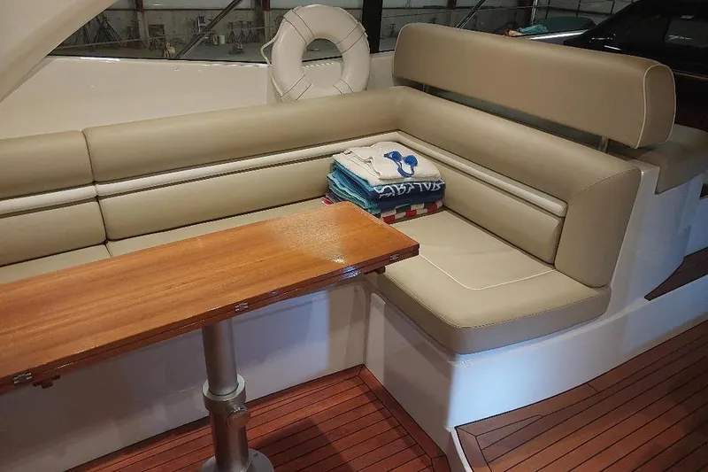 Slide: The Image of Luxurious interior of 2012 Sunseeker Portofino 48 yacht with beige seating and wooden table. - 5