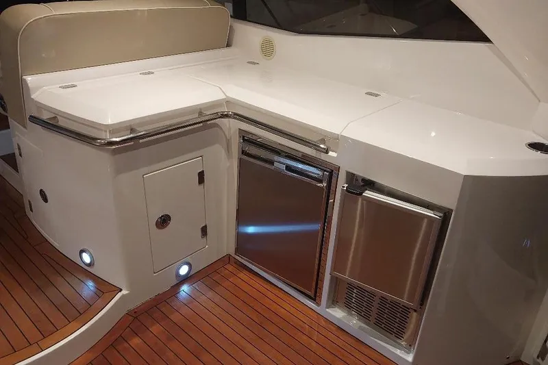 Slide: The Image of Luxurious 2012 Sunseeker Portofino 48 yacht interior with sleek kitchenette and wooden flooring. - 7