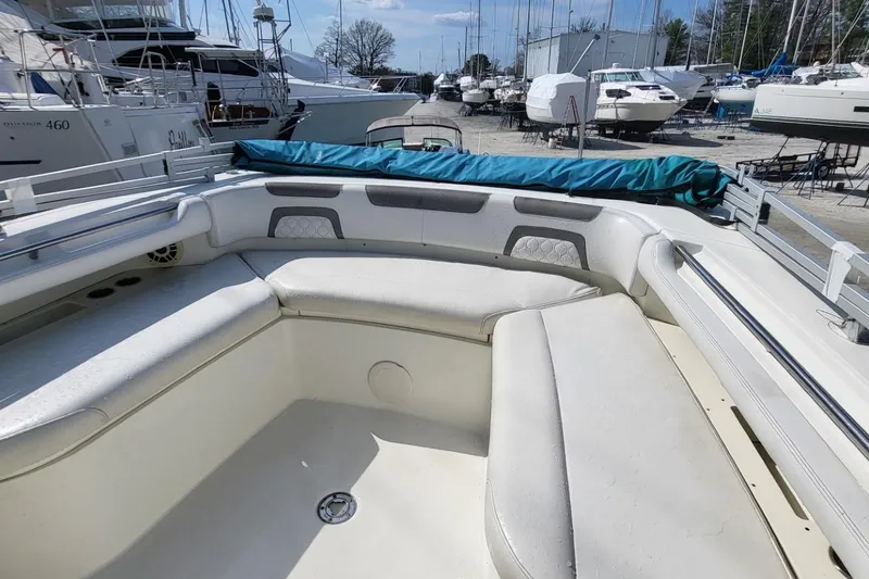 Slide: The Image of 2019 World Cat 320 CC boat interior with cushioned seating, docked among other boats. - 10