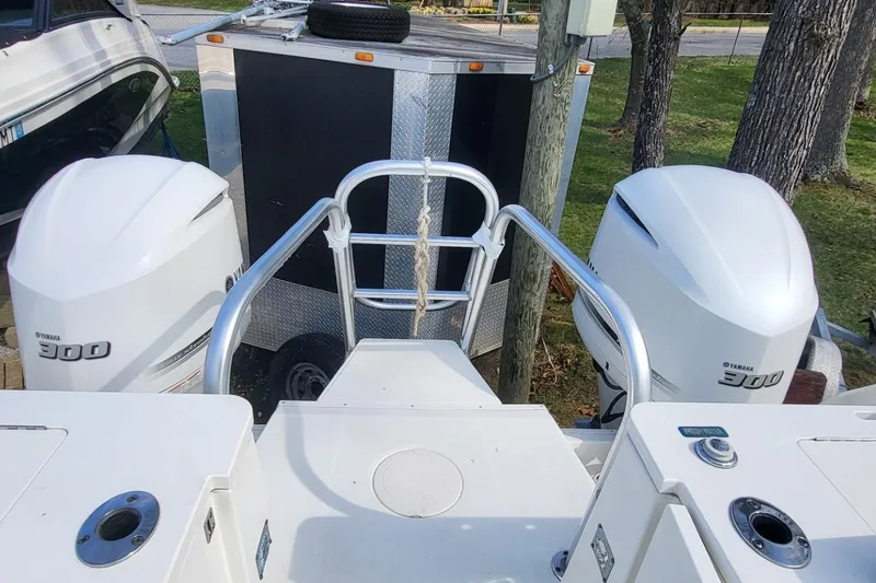 Slide: The Image of 2019 World Cat 320 CC boat with twin Yamaha 300 engines, parked near a trailer. - 12