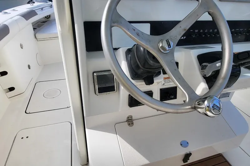 Slide: The Image of Steering wheel and controls of a 2019 World Cat 320 CC boat. - 19