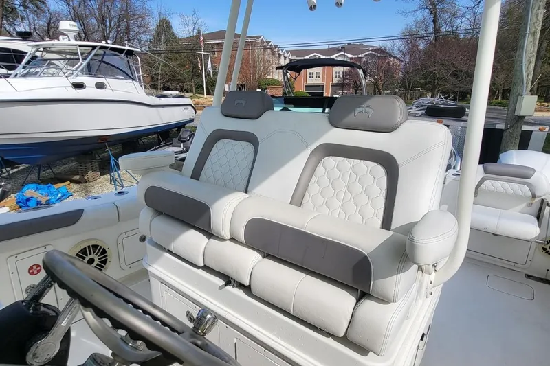 Slide: The Image of 2019 World Cat 320 CC boat interior with plush seating and steering wheel. - 21
